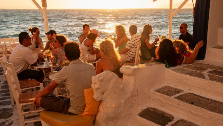 Turiști la o terasă de pe insula Mykonos din Grecia