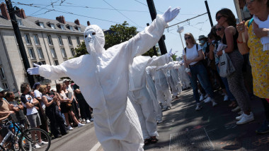 protestatari francezi imbracati in combinezoane si masti albe pe strada