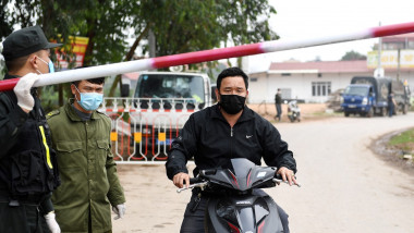 barbat pe scuter cu masca si autoritati in vietnam