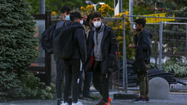 Migranți care poartă mască