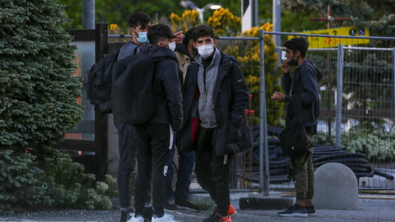 Migranți care poartă mască