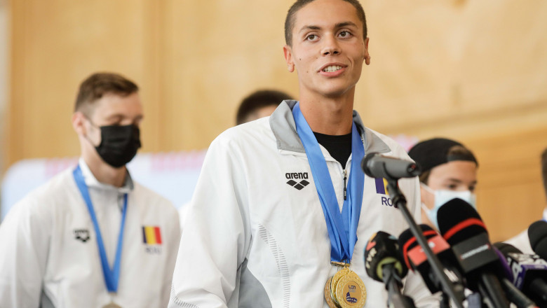 David Popovici, cu medalii la gât la sosirea pe aeroportul Otopeni.