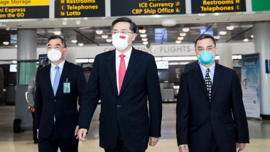 ambasadorul Qin Gang (centru), cu masca pe figura, la sosirea pe aeroportul JFK din New York.