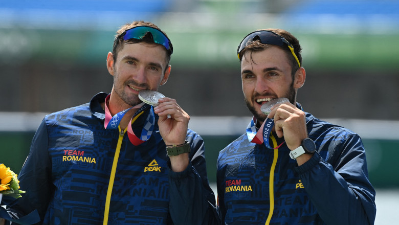 (L-R)Silver medallists Romania's Marius Cozmiuc and Ciprian Tudosa pose on the podium following the men's pair final during the Tokyo 2020 Olympic Games