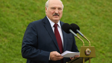 Aleksandr Lukașenko în fața unor microfoane cu hârtii în mână