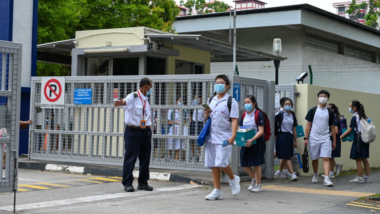 elevi cu masca indrumati de un paznic spre iesirea din scoala