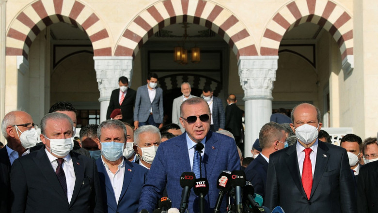 Erdogan la o conferință de presă înconjurat de mai mulți oameni cu mască