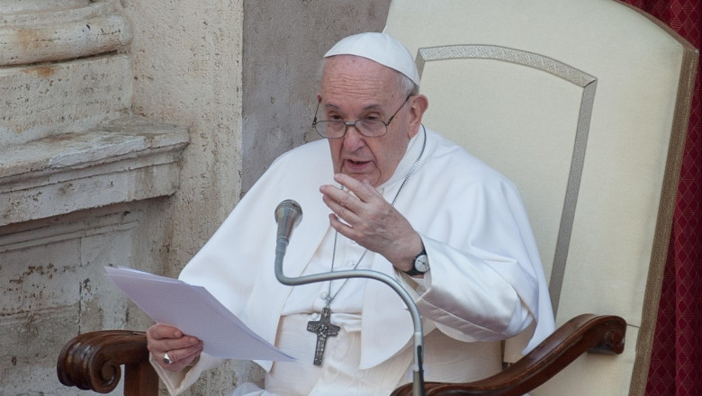 papa francisc sta pe scaun cu o foaie in mana si rosteste o predica