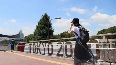 Tokyo, Japan. 19th July, 2021. A woman walks past the Tokyo 2020 Summer Olympic Games branding in Harajuku. Credit: SOPA Images Limited/Alamy Live News