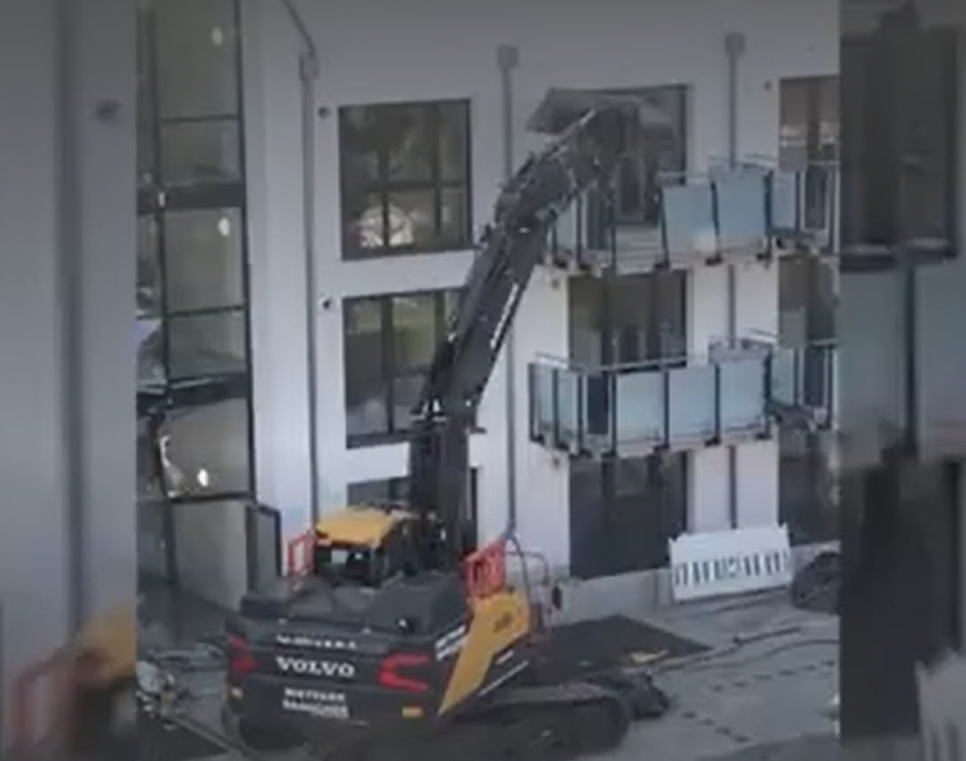 VIDEO. Pentru ca nu a fost platit la timp, un constructor a inchiriat un excavator si a inceput sa darame blocul pe care il ridicase