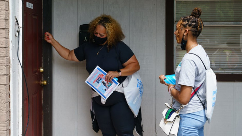 Voluntarii și membrii personalului medical bat la o ușă în timpul unui efort de extindere în comunitate a campaniei de vaccinare din orașul Birmingham, care e situat în statul Alabama