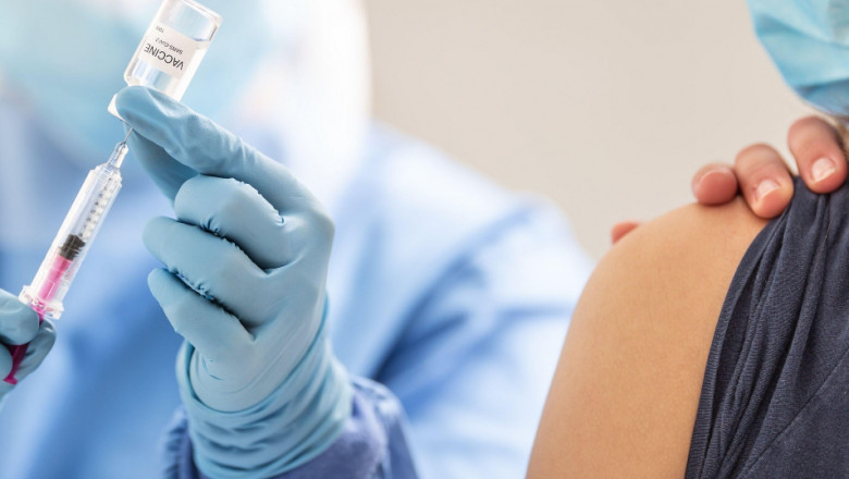 O femeie este vaccinată anti-COVID de un cadru medical.