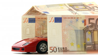 ilustratie cu o masina rosie care iese dintr-o casa construita din bancnote euro