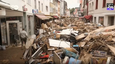 gramezi de resturi de lemn si alte deseuri ramase dupa inundatii pe o strada comerciala dintr-un oras german