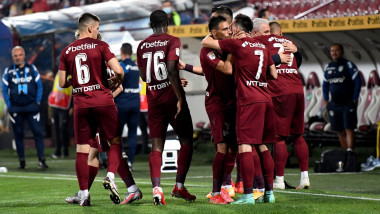 Jucătorii lui CFR Cluj se îmbrățișează pe teren.