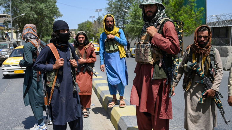 Taliban fighters stand guard along a street near the Zanbaq Square in Kabul on August 16, 2021
