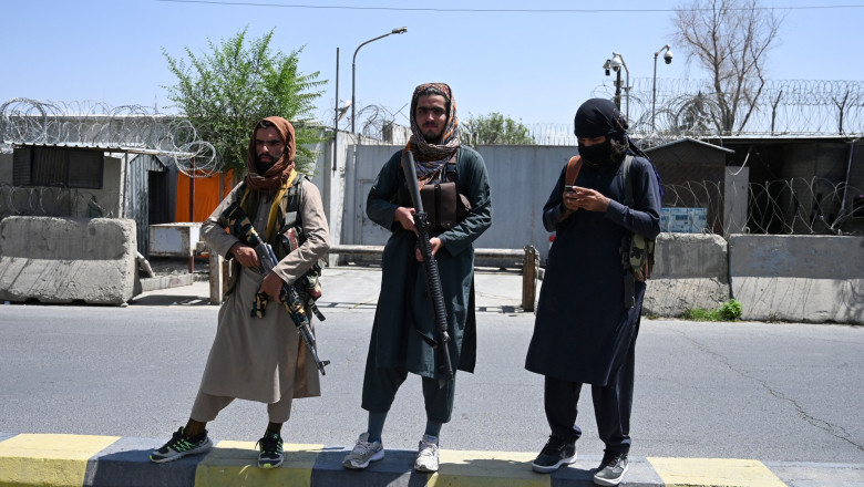 Taliban fighters stand guard along a street in Kabul on August 16, 2021