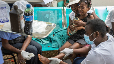 Un medic îngrijește piciorul unei fete rănite în cutremurul puternic din Haiti din august 2021