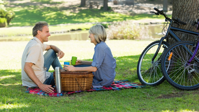 un barbat și o femeie stau la picnic în parc