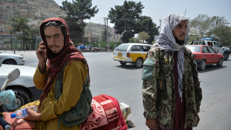 Taliban fighters stand along a road in Kabul on August 18, 2021