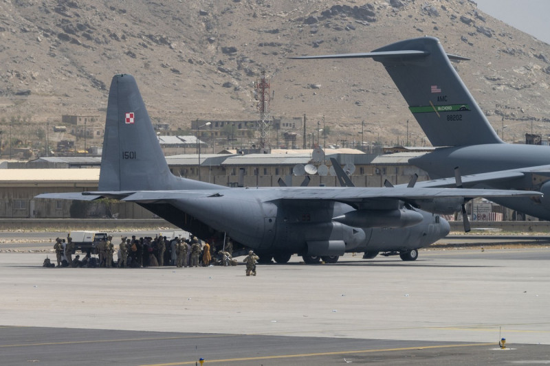 Oameni intrând într-un avion militar pe aeroportul din Kabul în timpul evacuării personalului militar și diplomatic după căderea țării în mâinile talibanilor
