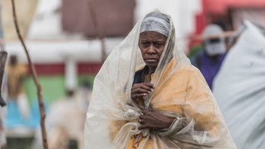 Femeie cu un sac de plastic în cap, ferindu-se de ploile aduse de furtuna Grace în Haiti după cutremurul masiv din august 2021
