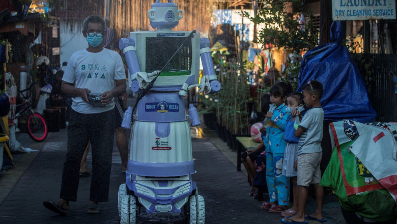 Aseyan operates a disinfection robot named Delta, which he created from recycled household goods, at a neighbourhood in Surabaya