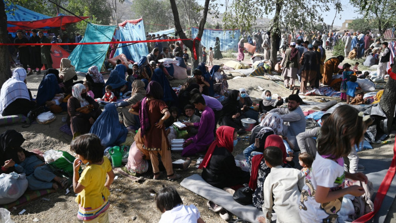Internally displaced Afghan families, who fled from Kunduz and Takhar province due to battles between Taliban and Afghan security forces, sit in a field in Kabul