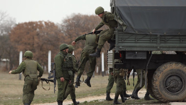 Trupele aflate sub comanda rusă coboară dintr-un camion militar la baza aeriană Belbek, pe care trupele ruse au ocupat-o în Crimeea pe 4 martie 2014