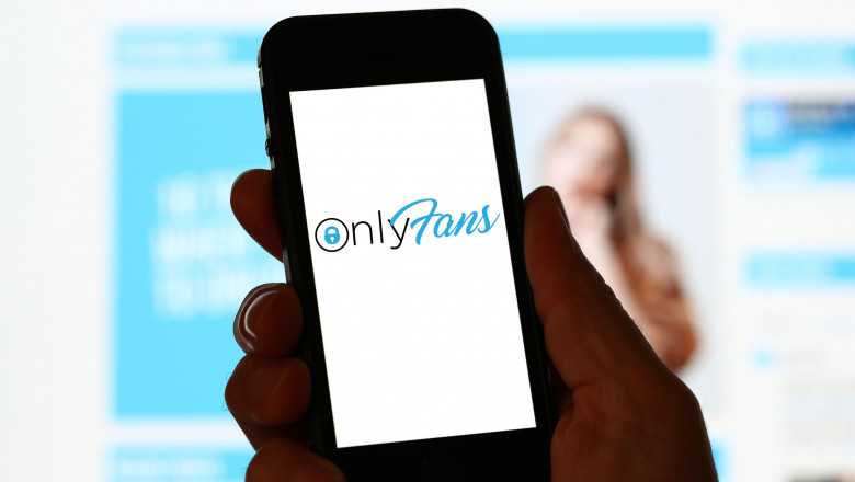 A man looking at OnlyFans website on a computer and mobile phone
