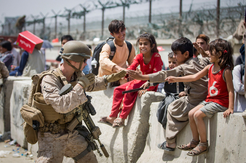 A Marine with Special Purpose Marine Air-Ground Task Force-Crisis Response-Central Command (SPMAGTF-CR-CC) plays with children waiting to process during an evacuation at Hamid Karzai International Airport, Kabul, Afghanistan, Aug. 20. U.S. service members