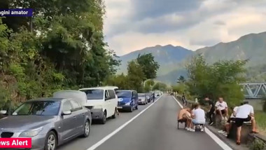 tineri care joaca table in drum in timpul unui blocaj in trafic