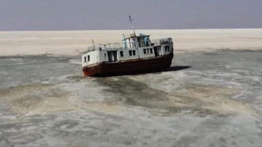 Ilustrație cu un feribot blocat pe lacul Urmia care se usucă.