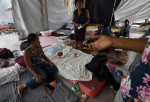 Oameni într-un cort improvizat, în Haiti