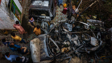 Relatives and neighbors of the Ahmadi family gathered around the incinerated husk of a vehicle targeted and hit earlier Sunday afternoon by an American drone strike, in Kabul, Afghanistan