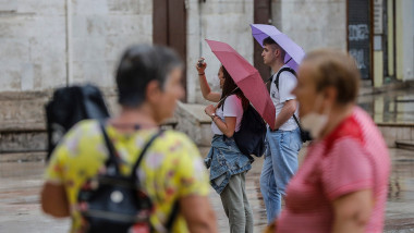 Several people hold an umbrella while it rains, on July 26, 2021, in Valencia, Valencian Community, (Spain)