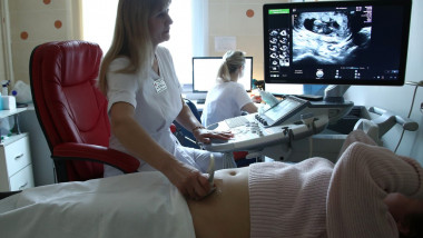 Un medic face o ecografie unei femei însărcinate.