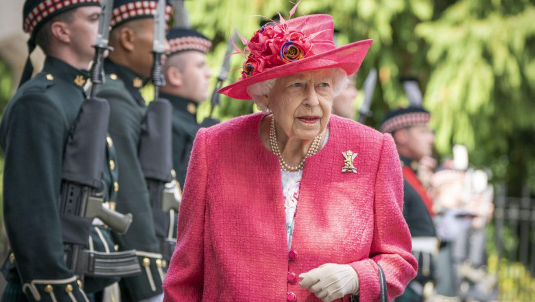 Regina Elisabeta a II-a îmbrăcată în roz trece pe lângă militari