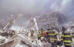 Pompieri stau pe moloz și rămășițele turnurilor gemene