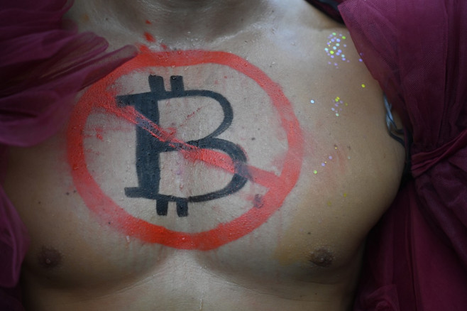 pieptul unui bărbat pictat cu un simbol anti-bitcoin