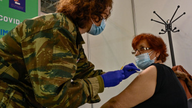 un medic militar vaccineaza o femeie in grecia