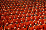 Sute de oameni aliniați, îmbrăcați în costume de protecție la o paradă militară a coreei de nord