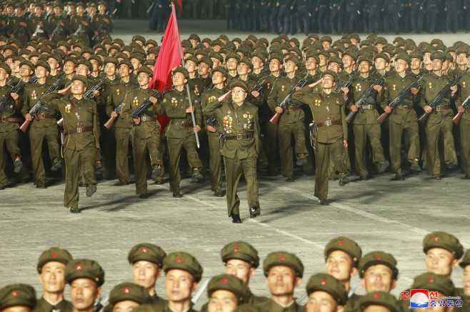 Soldați nord-coreeni cu un steag roșu