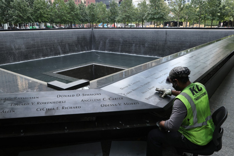 un muncitor lustruiește memorialul 9/11