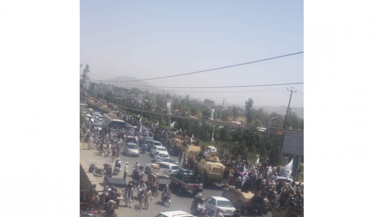 mulțime și convoi de vehicule blindate pe străzile din Kandahar