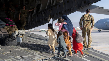 femeie cu copii care se urca intr-un avion militar