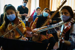 Fete cu mască de protecție exersează la instrumente muzicale