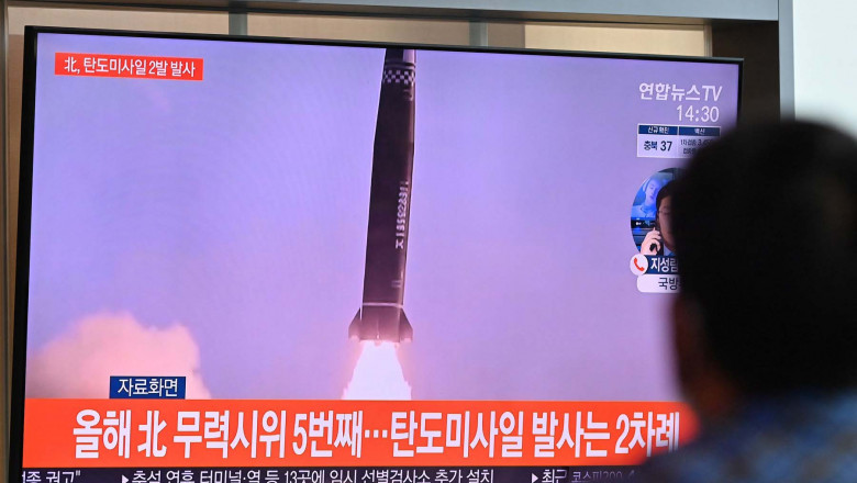 A man watches a television news broadcast showing file footage of a North Korean missile test, at a railway station in Seoul on September 15, 2021