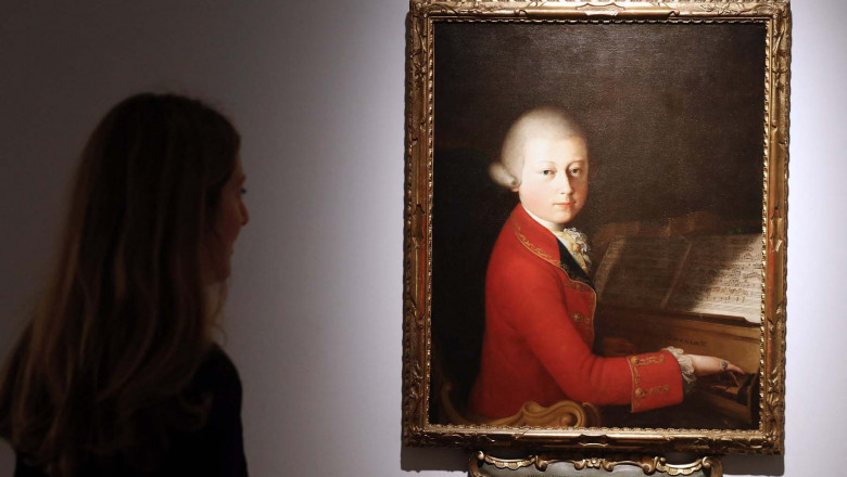 A woman looks at a painting showing a portrait of Austrian composer Wolfgang Amadeus Mozart at the age of 13, dated from 1770 and attributed to Italian painter Giambettino Cignaroli