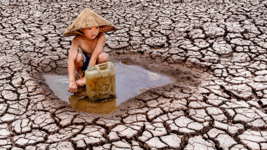 copil adunând apă